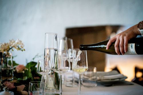 The Best Wineries to Visit in Charlottesville. Wine being poured in glasses on a table.